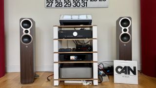 Q Acoustics 3040c speakers in a white listening room, with a hi-fi stack and turntable between them